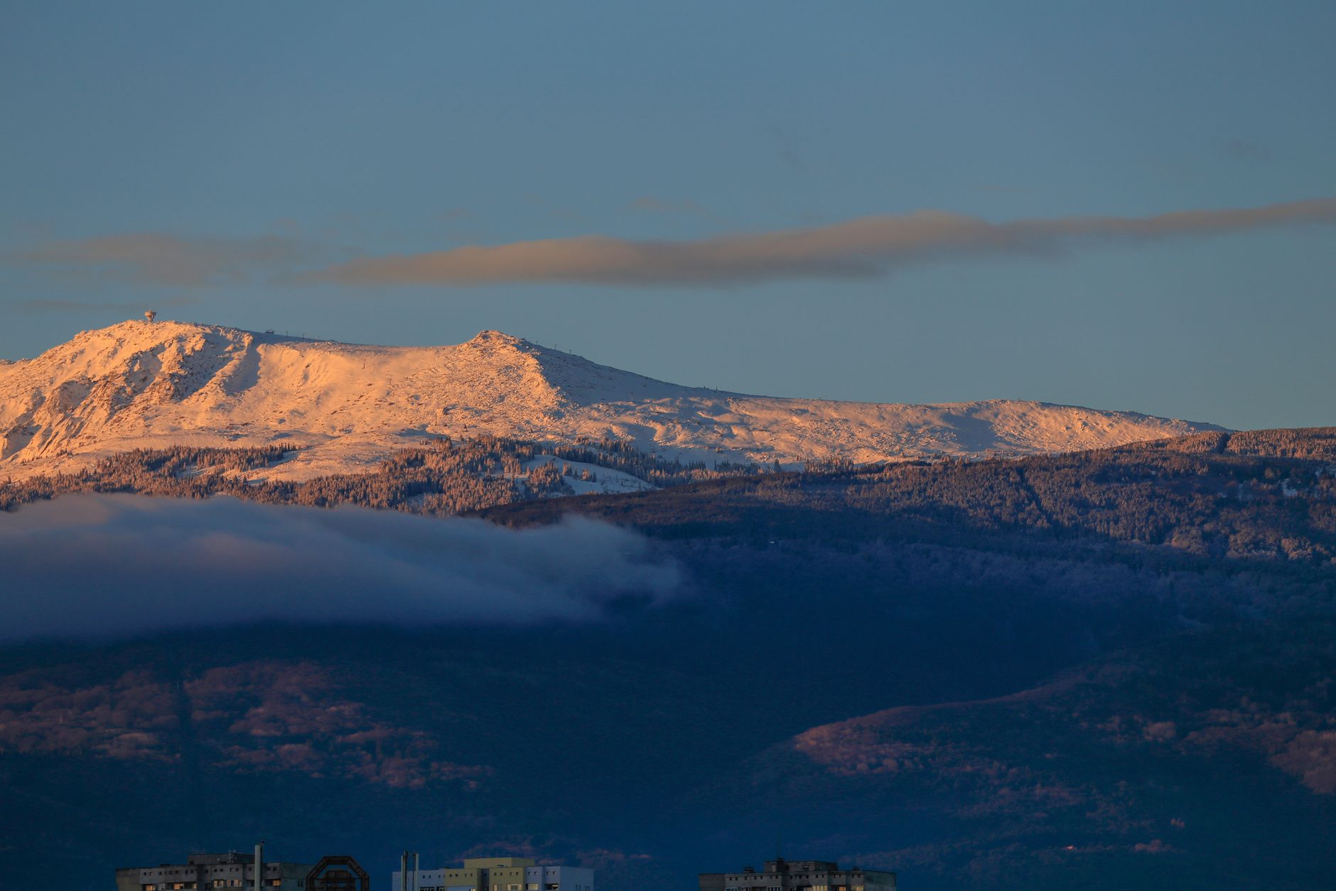Mount Vitosha snow-covered peaks rising behind the gold domes of Alexander Nevsky Cathedral